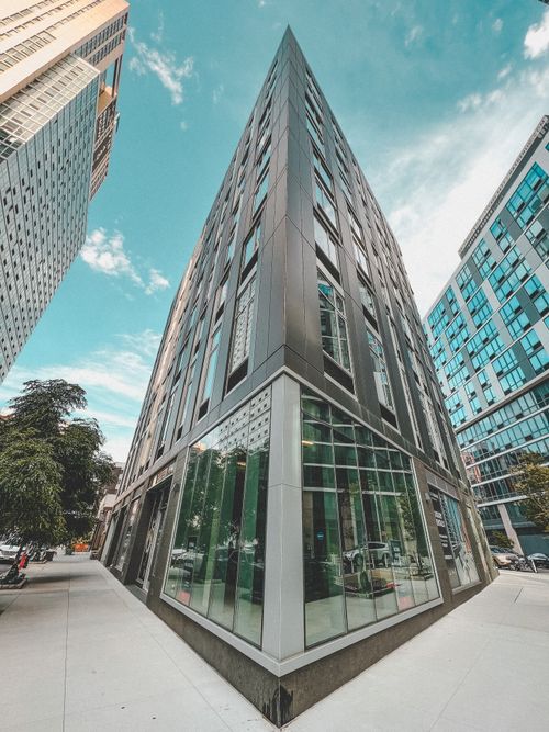 Free Dynamic low angle capture of a downtown skyscraper with glass facades on a sunny day. Stock Photo