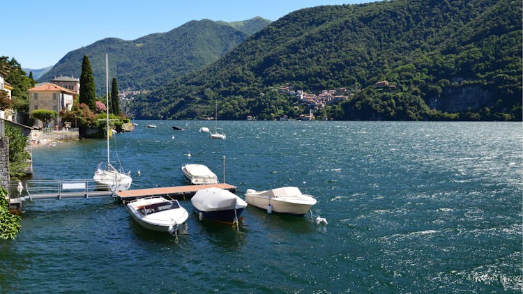 Sailboats Docked On A Jetty Outside A House