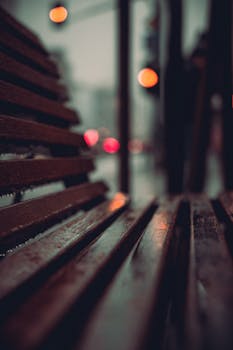 A wooden bench in city at night, captured with bokeh lights in Warsaw.