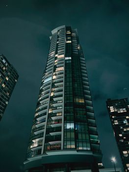A dramatic low-angle view of a high-rise building against a night sky, showcasing urban architecture.