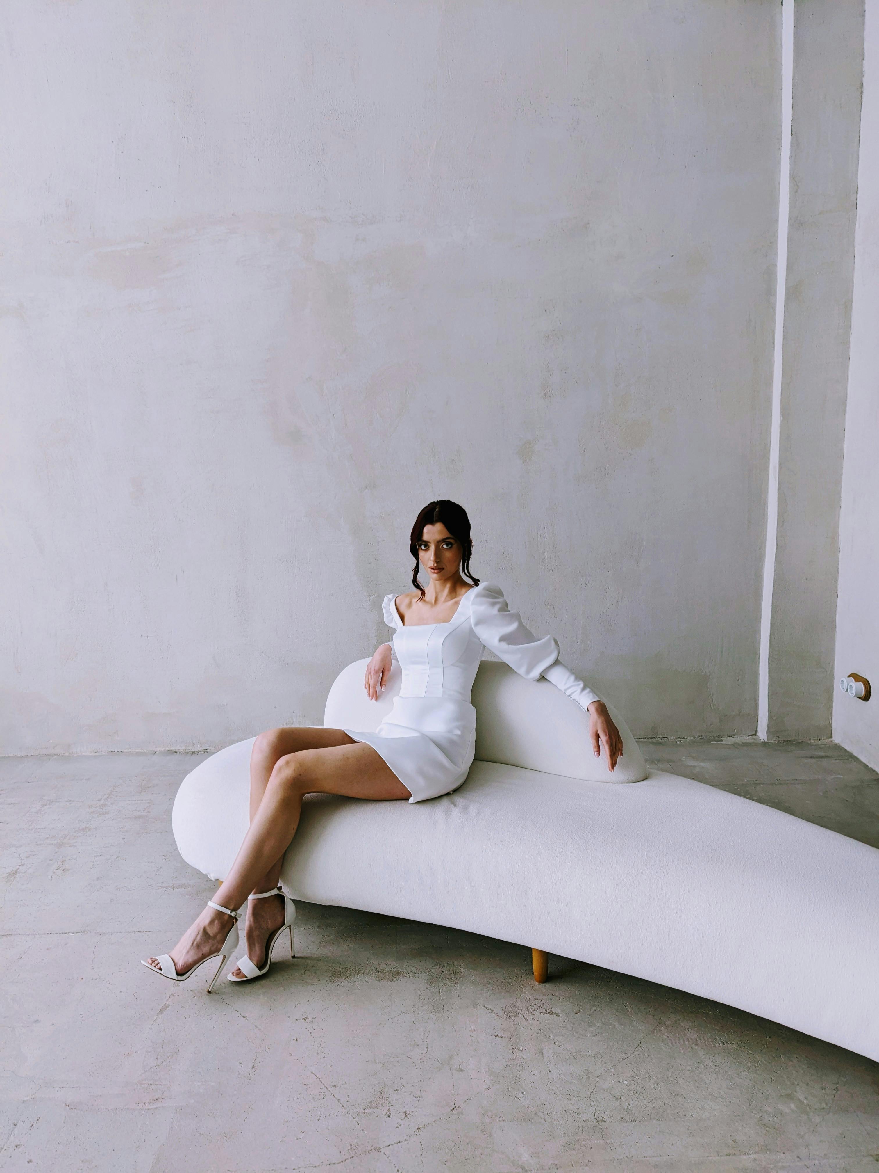 woman in white dress sitting on couch