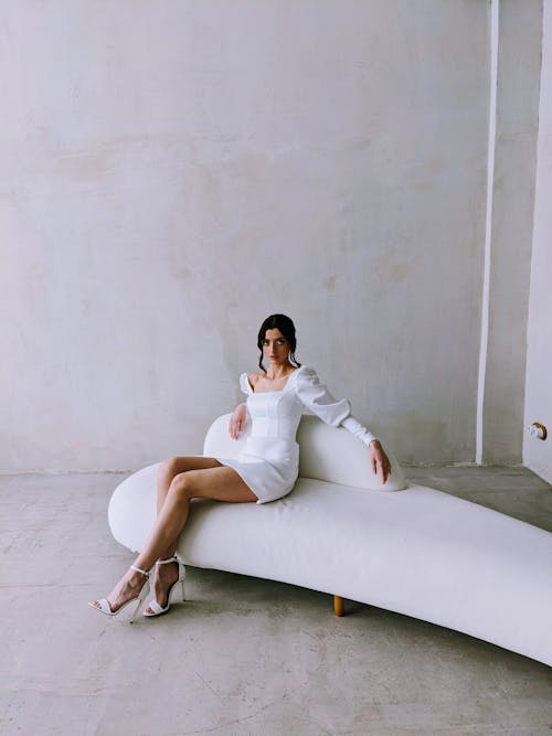 Woman in White Dress Sitting on Couch