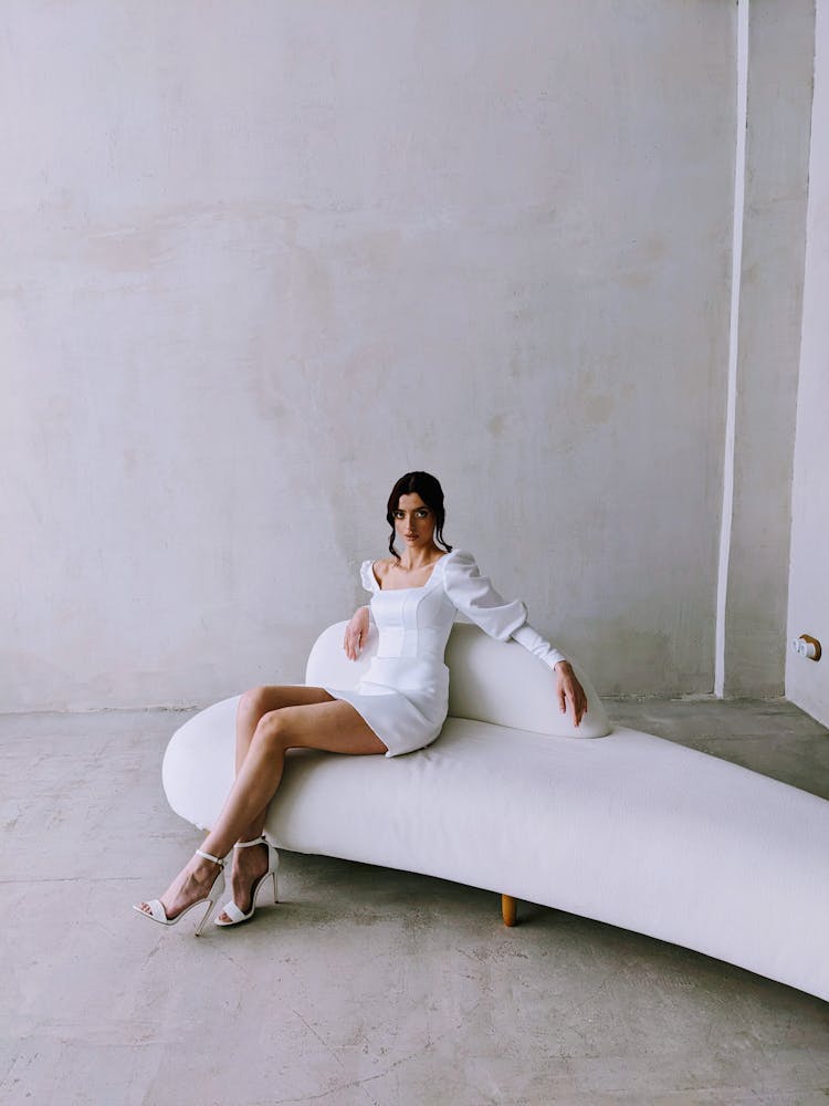 Woman In White Dress Sitting On Couch