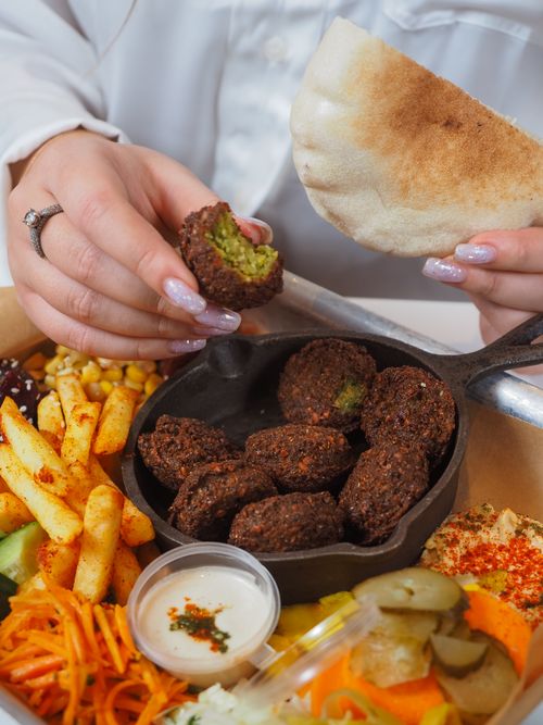 Free Appetizing falafel in skillet with pita bread, vegetables, and dips. Stock Photo