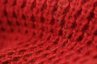 宏观镜头细致地突出了红色羊毛面料的质感，非常适合冬季主题