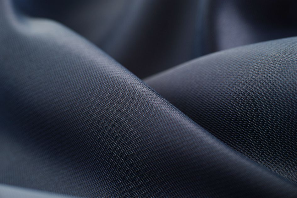 Vải lụa polyester màu navy cho thấy độ rủ và bề mặt mờ nhẹ