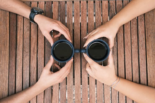 Hands Holding Cup of Black Coffee 