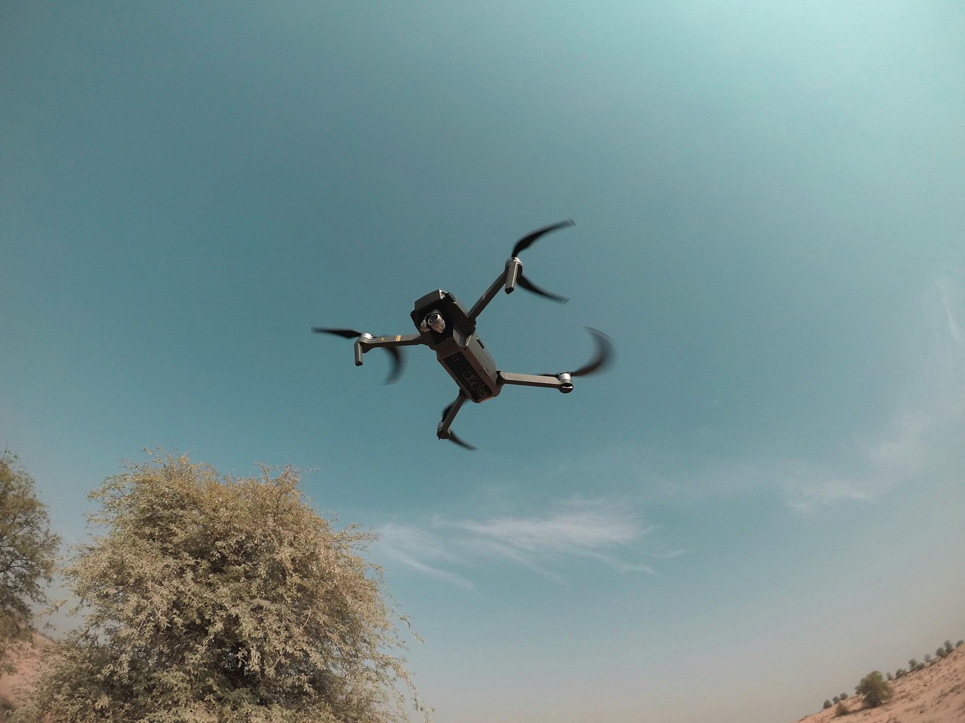 Drone flying over desert landscape in Dubai, showcasing technology and recreation.