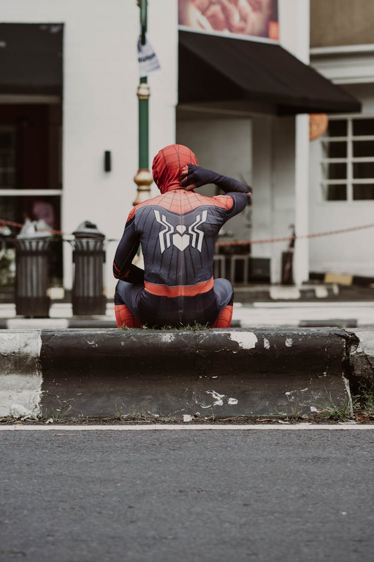 Spiderman Sitting On Wall Near Street