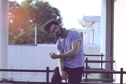 一名年轻人摆出休闲的姿势，在户外散发着轻松无忧无虑的氛围