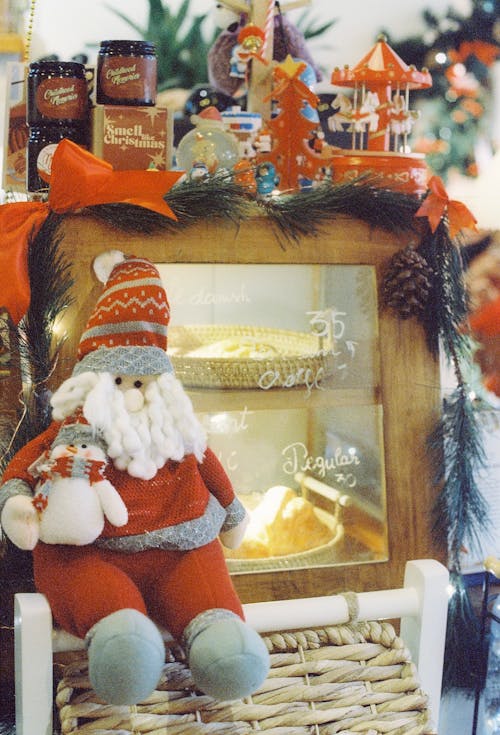 Santa Claus Stuffed Toy  in Front of a Bread Cabinet