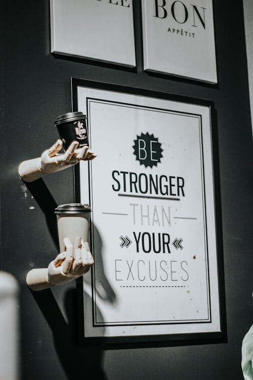 Close-up of Framed Pictures on a Wall and Statues of Hands Holding Coffee Cups 