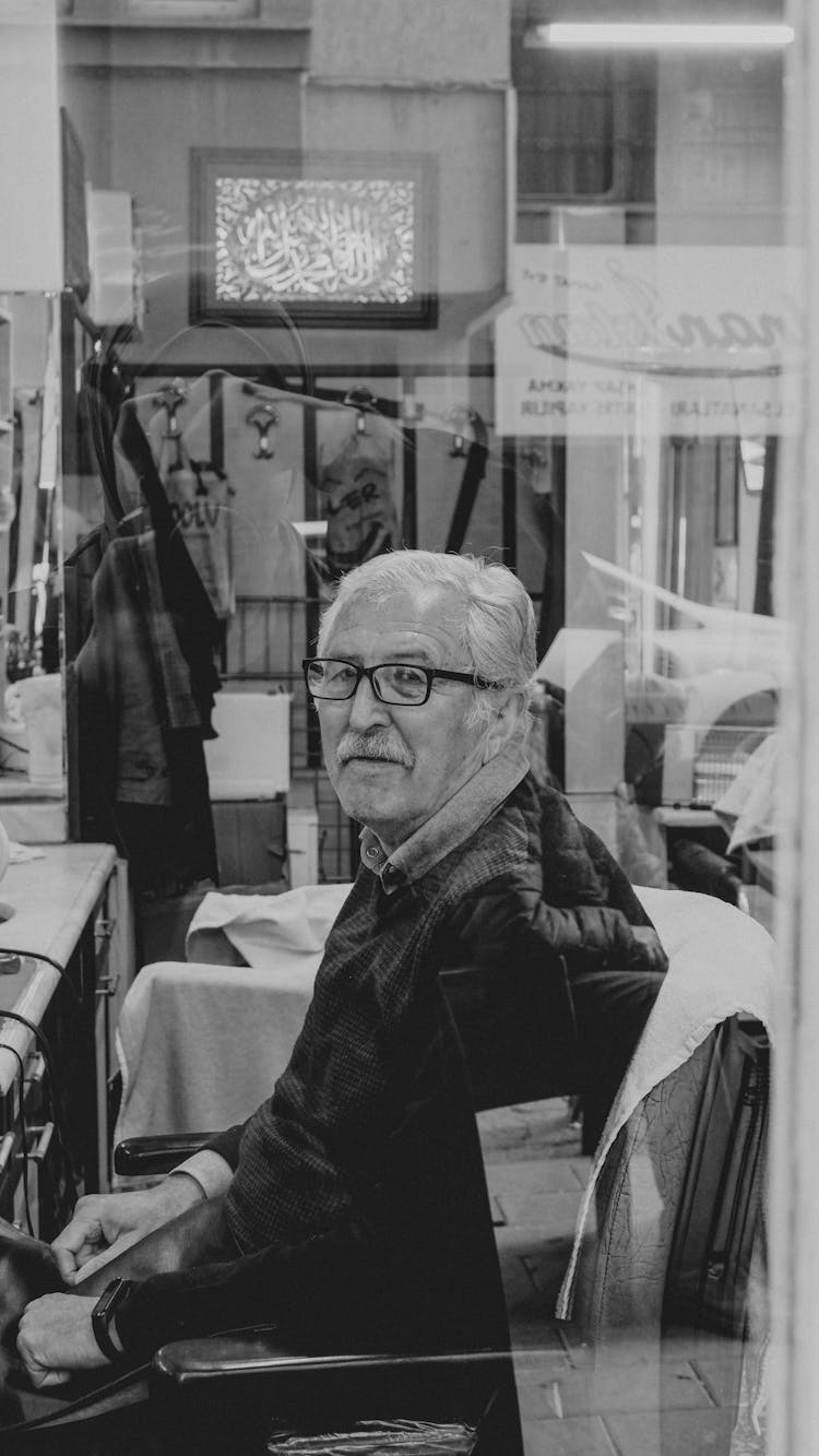 Black An White Photo Of An Elderly Man Behind The Glass