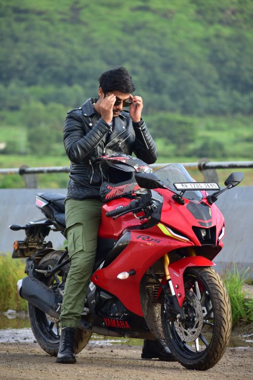 Free Confident biker with sunglasses on a red Yamaha bike, outdoors lifestyle scene. Stock Photo