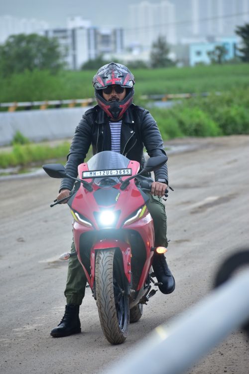 Free Man in black leather jacket on a red sports motorcycle on open road. Stock Photo