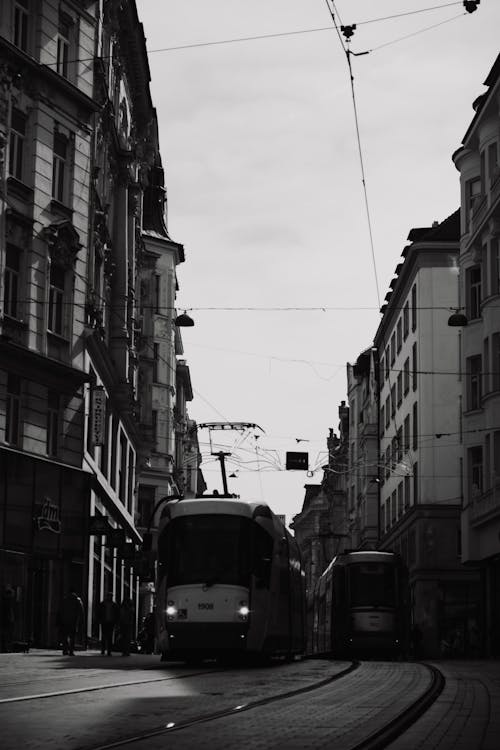 Grayscale Photo of Trams in between Buildings