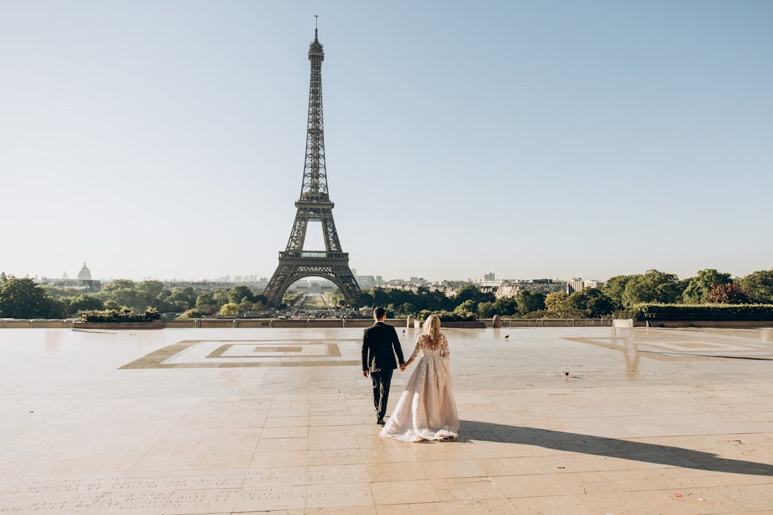 Woman and Man Walking in Park in Front of Eiffel Tower