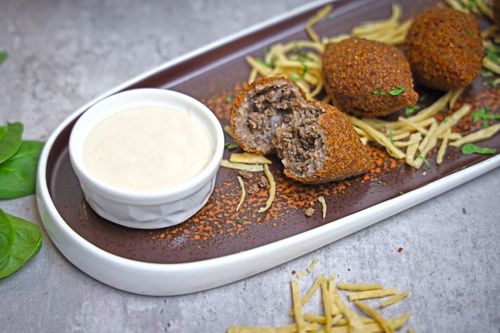 Free Delicious Middle Eastern kibbeh served with creamy tahini sauce, perfect for a savory meal. Stock Photo