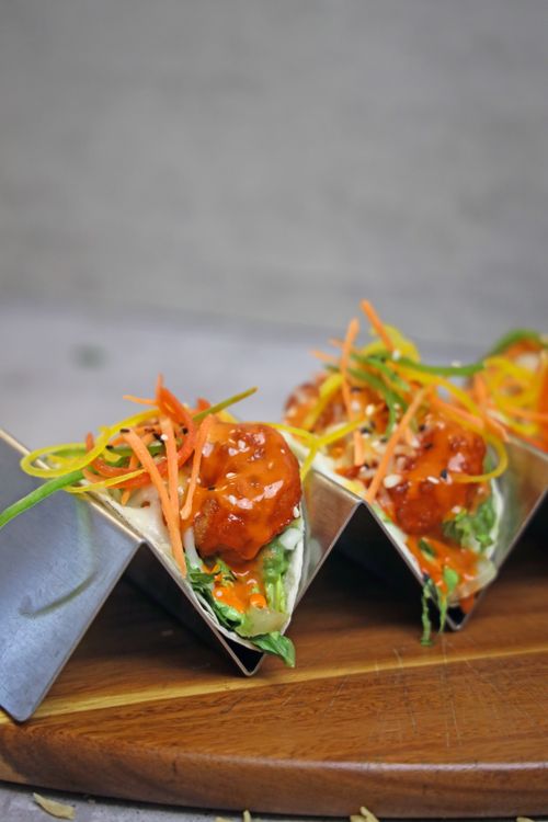 Free Delicious spicy chicken tacos topped with fresh vegetables on a wooden board. Stock Photo