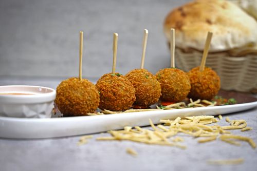 Free Tasty golden appetizer balls served with a spicy sauce, perfect for gatherings. Stock Photo