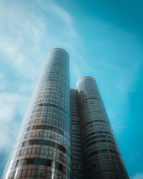 Free Futuristic skyscraper against a clear blue sky in Paris, conveying modernity. Stock Photo