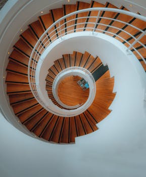 Top view of a circular spiral staircase with wooden steps in a modern building in Paris.