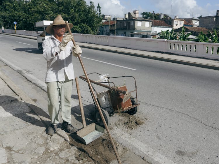 Man Cleaning Street In Town