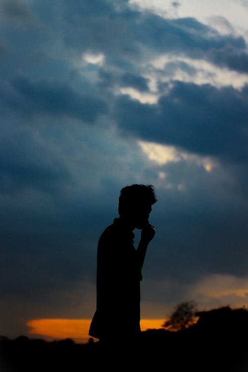 Silhouette of a Man on the Background of a Sunset Sky 