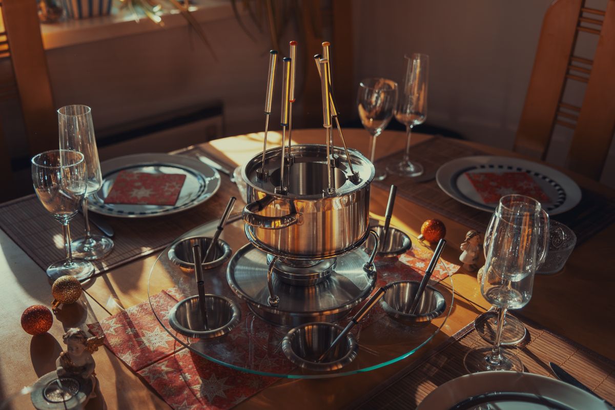 A fondue set on a warmly lit chalet table