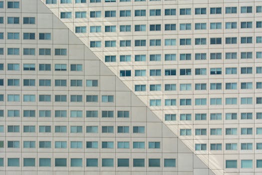 Close-up of a modern building facade showcasing geometric patterns and glass windows.