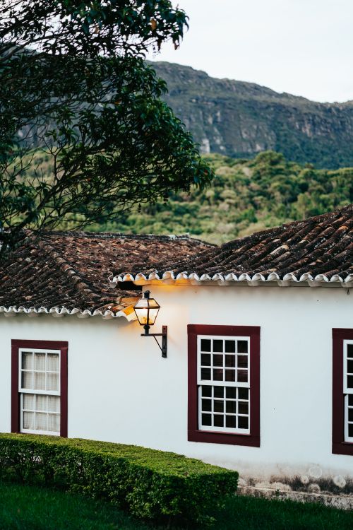 Free Rustic colonial house in Tiradentes, Brazil, with scenic mountains and greenery. Stock Photo