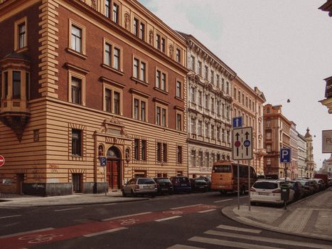 Beautiful historic buildings and street scene in Prague, featuring urban architecture and parked vehicles.