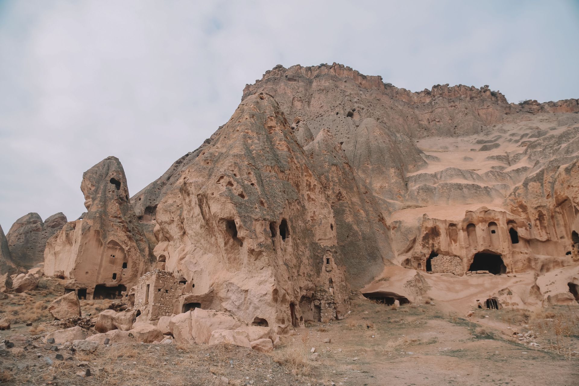 Explore the ancient rock-cut caves in Cappadocia's rugged landscape.