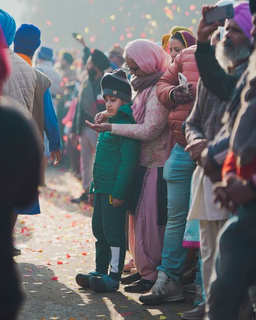 Free A joyful celebration with people in traditional clothes, crowds, and colorful confetti outdoors. Stock Photo