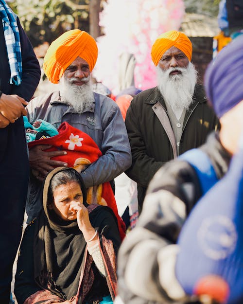 Elderly Men in Turbans and Woman with a Headscarf in the Crowd 