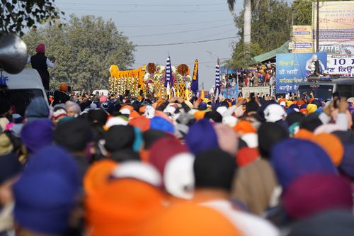 Free A vibrant street festival with a large gathering of people wearing colorful headgear, showcasing cultural diversity. Stock Photo
