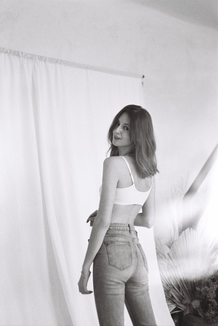 Woman In Top And Jeans Posing Indoors