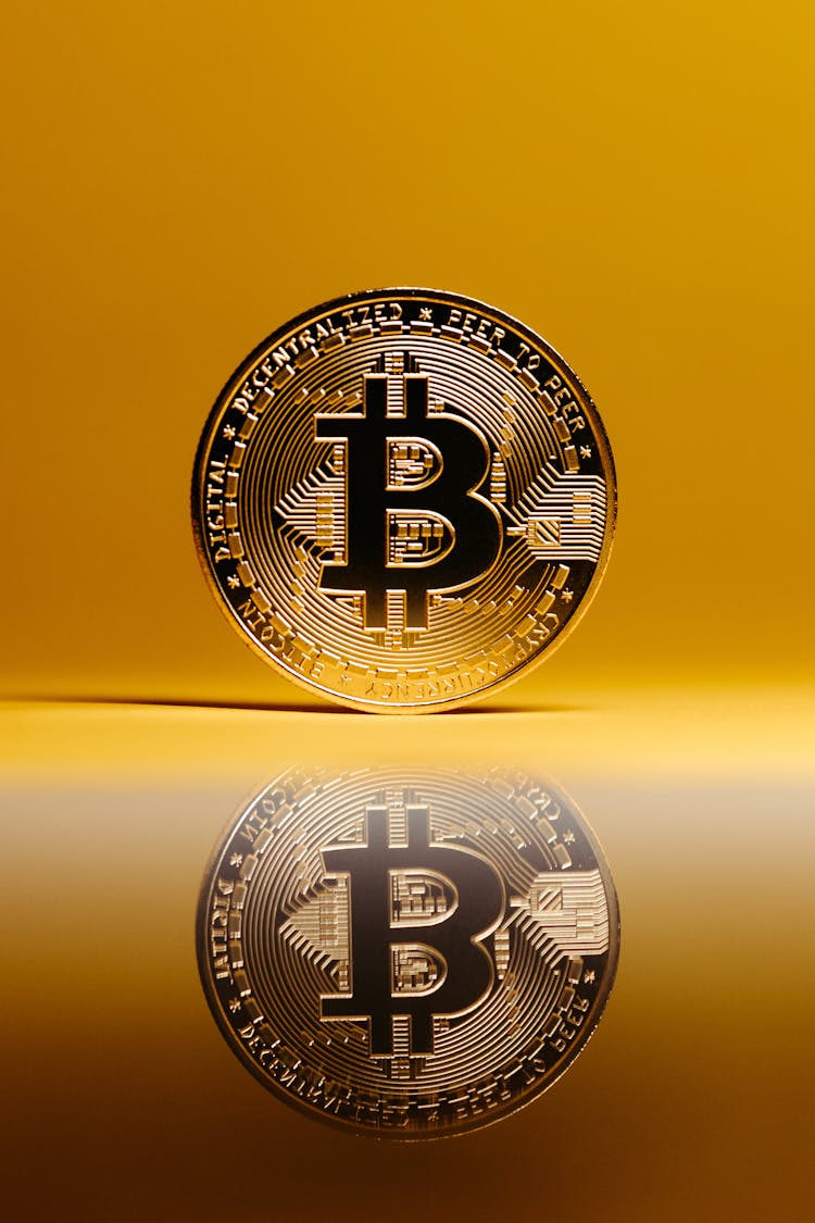 Bitcoin With Reflection On Surface On Yellow Background