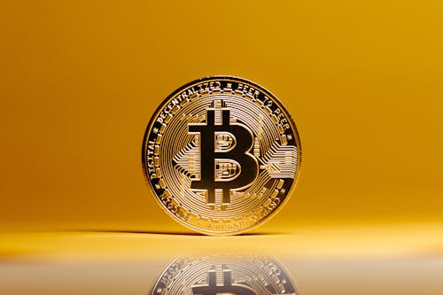 Free Bitcoin on Yellow Studio Background Stock Photo