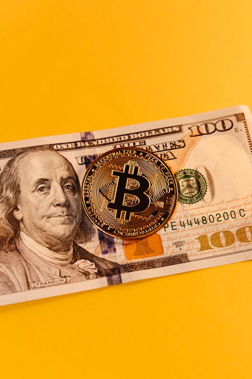 Bitcoin and Dollar Banknote on Yellow Background