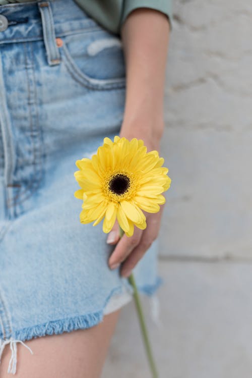 A Woman Holding a Yellow Flower