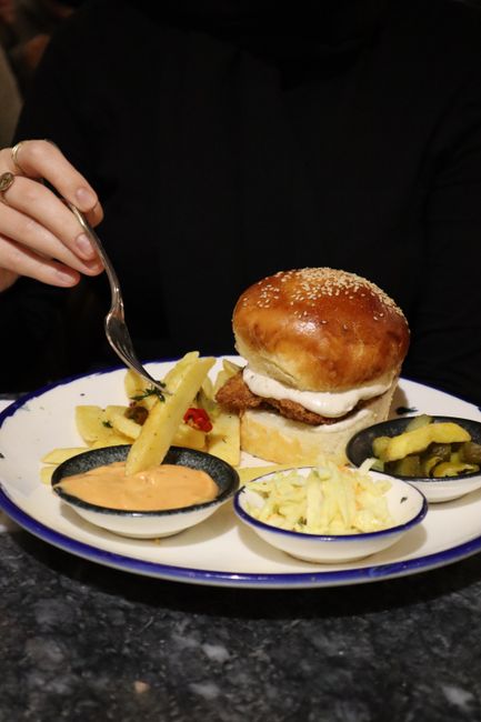 Fiskeburger serveret med pommes frites og coleslaw