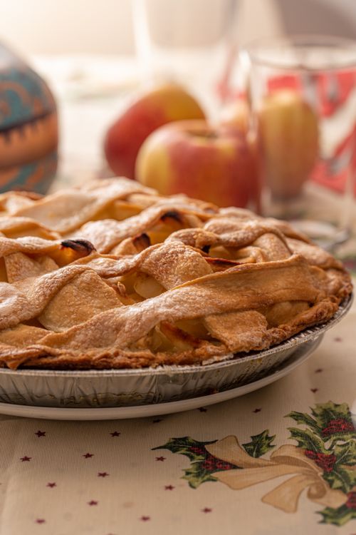 Free Delicious homemade apple pie with lattice crust on a festive tablecloth. Stock Photo