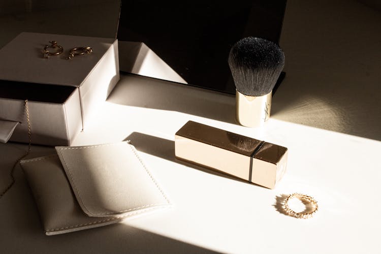 Jewelry And A Makeup Brush On A Table 