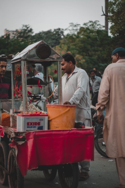 Free A street vendor selling popcorn at a bustling outdoor market. Stock Photo