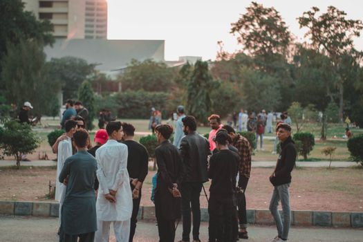 A group of young adults gathered in an outdoor park setting, enjoying a casual day. - Fotografer Sidoarjo