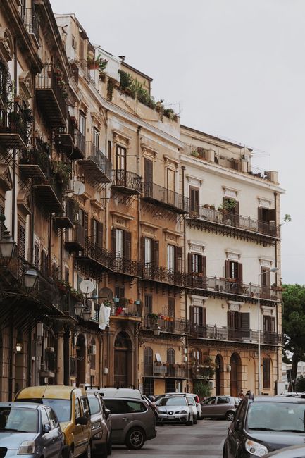 European residential street with parked cars and historical buildings.