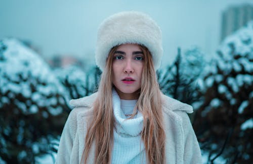 A Woman in White Fur Hat Looking with a Serious Face