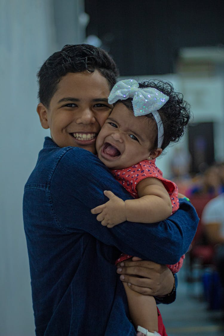 Boy Holding Little Girl In Hands