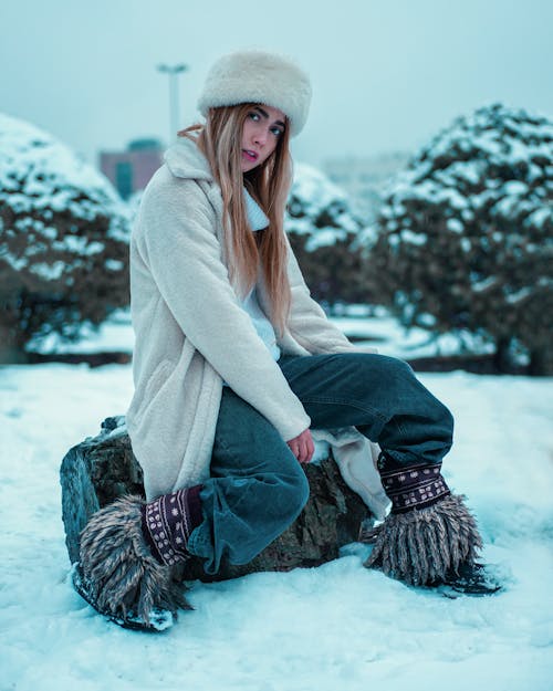 A Woman in Winter Clothes Sitting